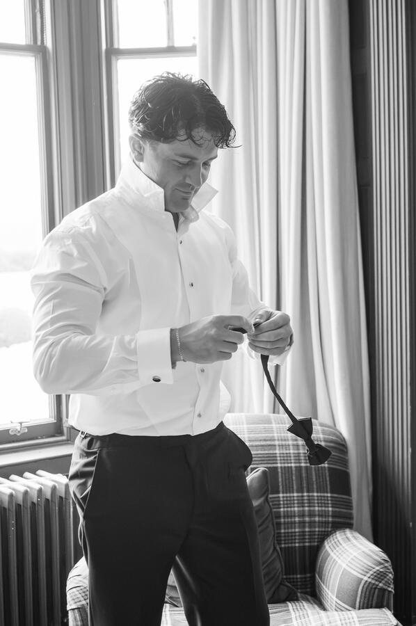 Groom getting his bow tie on for his wedding day in Scotland.